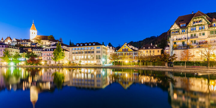 Switzerland, Canton of Bern, Thun, river Aare, old town with parish church and Aarequai at blue hour