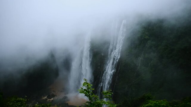 Majestic Jog Falls in Karnataka, India, cascades powerfully amidst swirling mist and lush green landscapes, capturing the raw beauty of nature during monsoon season.