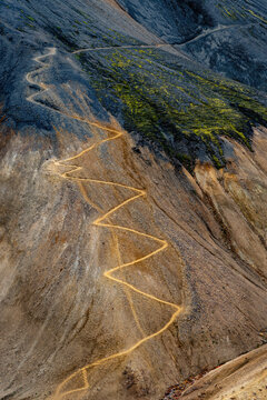 View of the zigzagging hiking trail winding up the steep, colorful volcanic slopes of Landmannalaugar in Rangarthing ytra, Iceland.