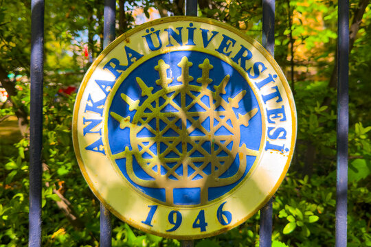 Ankara, Turkey - April 25, 2026: Official metal emblem logo plaque of Ankara University attached to wrought iron fence in green campus park (Ankara &Uuml;niversitesi, Ankara, T&uuml;rkiye)