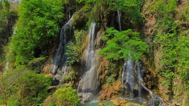 Aerial view of Sri Gethuk Waterfall cascading over rocky cliffs surrounded by lush tropical vegetation in Yogyakarta, Special Region of Yogyakarta, Indonesia.
