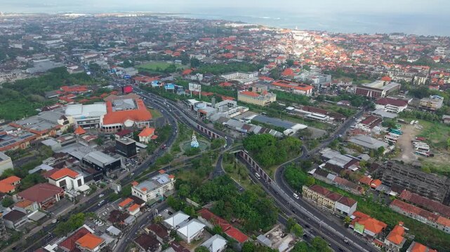 Aerial view of Statue of Dewa Ruci surrounded by urban infrastructure, roads, and buildings in Kecamatan Kuta, Bali, Indonesia.
