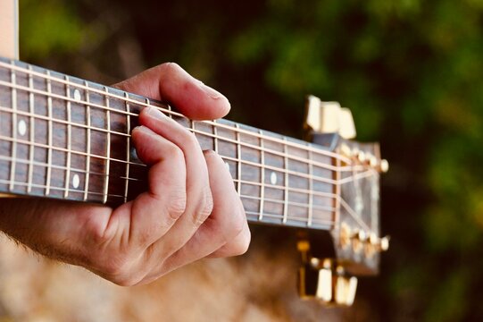 Detailed close-up view of fingers pressing steel strings during an intimate musical performance or studio session.