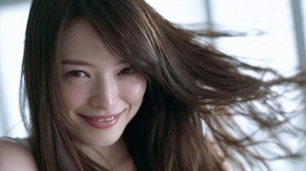Fototapeta premium An attractive Chinese woman showcasing her flowing dark hair against a clean white background for a luxury salon design.