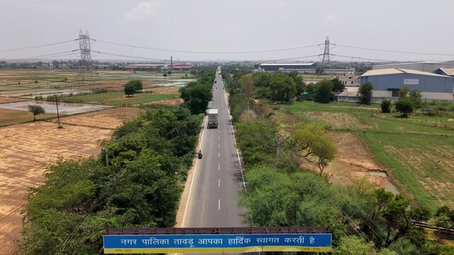 Drone aerial view of Tauru, Haryana with farmland, roads and industrial buildings