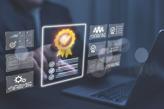 A businessman uses a laptop while interacting with a glowing digital quality certification. Multiple holographic screens show standard compliance checklists and team data graphics.