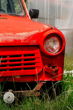 Vertical close-up photo of red Trabant front grille and round headlight real life photography
