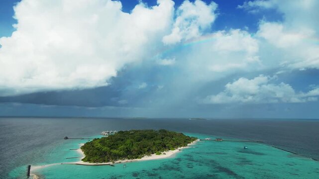 Aerial view of Meedhupparu island surrounded by turquoise lagoon waters and lush tropical vegetation in Raa Atoll, Raa Atoll, Maldives.