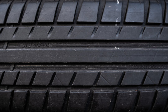 View of a black rubber car tire tread with detailed grooves and markings in Riga, Latvia.