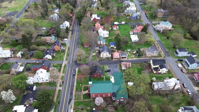 Distinctive green seam metal church roof anchors Washington Street intersection parcels. Historic multi story houses line rolling Appalachian ridges in Harpers Ferry, West Virginia