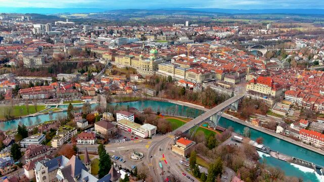 Aerial drone view of Bern with the turquoise Aare River, Kirchenfeld Bridge, the Federal Palace, Helvetiaplatz and the old town rooftops, Switzerland, in winter.