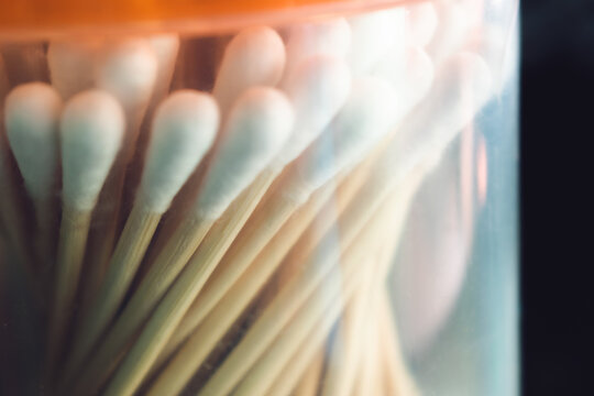 Close-up shot of cotton swabs in a transparent container, Bengaluru, India.  The composition emphasizes texture and pattern.