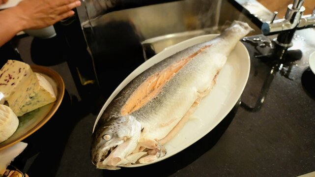 Whole Raw Gutted Trout Fish Prepared for Cooking on Plate in Kitchen
