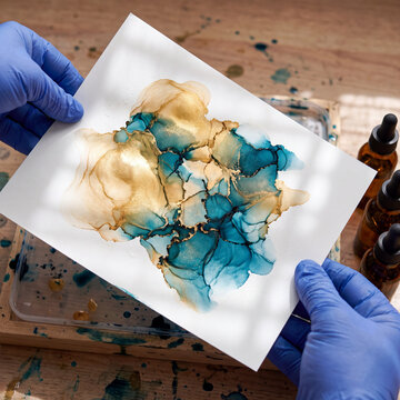 Gold and teal alcohol ink marbling on wet paper