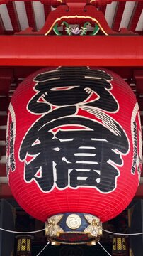 Large red chochin lantern hanging at Sensoji temple gate in Tokyo.
