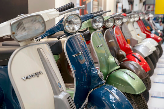 Numerous and colorful Vespas are lined up on display at the Piaggio museum in Pontedera, Pisa, Italy