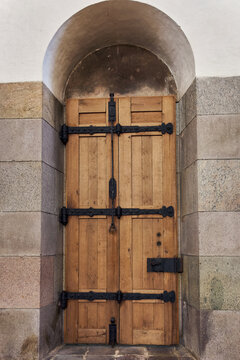 View of the historic wooden door with ornate black iron hinges and hardware at Ribe Cathedral in Ribe, Denmark.