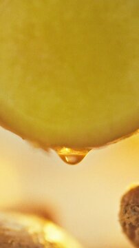 A freshly cut ginger rhizome on a wooden board drips clear juice, revealing its high vitamin and fiber content. The extraction process emphasizes the herb's pungent flavor and agricultural food value