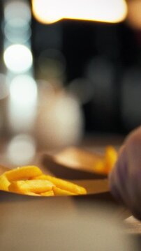 Tongs lift golden French fries onto paper plates in a bustling diner kitchen, a chef serving fast food to patrons, the scene humming with quick service and restaurant energy - fast food idea