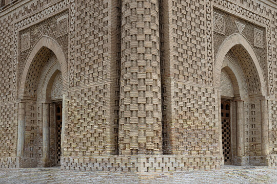Decorative brickwork facade of the Ismail Samani Mausoleum in Bukhara, Uzbekistan, showing intricate geometric patterns. Ideal for travel publications, architectural studies, and heritage content.