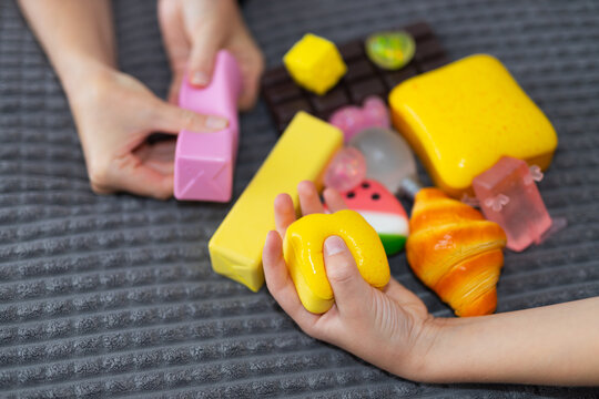 Two children playing with vibrant squishy toys and foam food pieces for kids playroom background and early learning activity design
