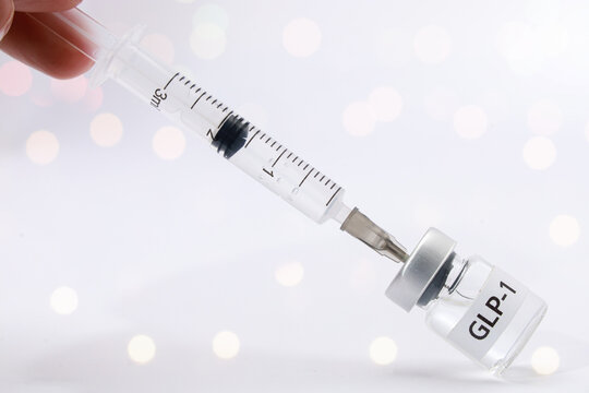 Medical syringe draws liquid glp 1 injection from glass vial with hopeful care showing health treatment concept on white bokeh background