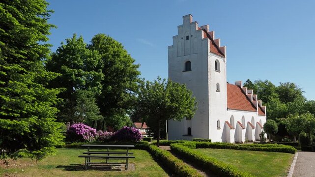 Traditional danish white church in a green garden