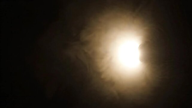 Soft glowing spotlight and lens flare orb in upper corner on black