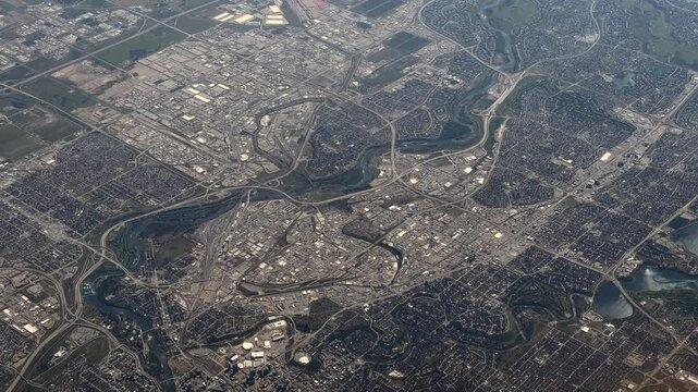 overflying City of Calgary, Alberta, Canada with suburbs, Bow River, Elbow River, city infrastructure, residential areas, industrial areas, and shopping centers - 4k aerial video footage