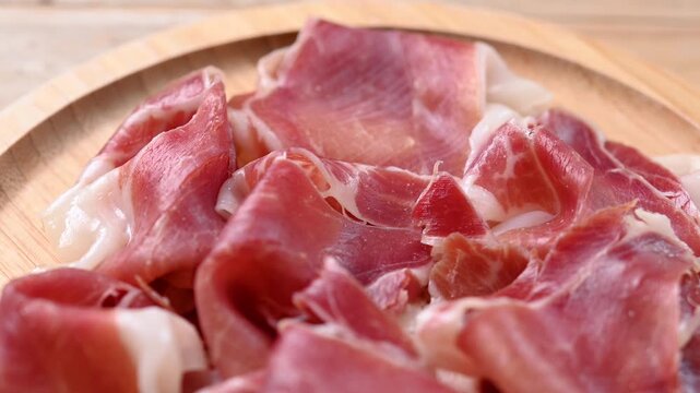 Spanish serrano ham slices on wooden table