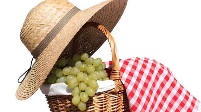 Wicker picnic basket with green grapes and straw hat