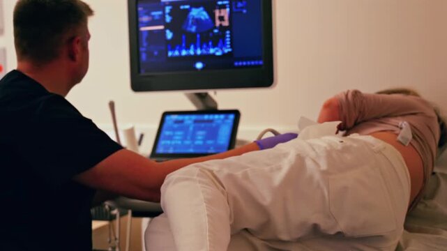 Professional medical specialist performing obstetric ultrasound examination for pregnant woman in modern clinic.