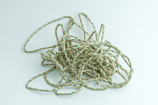 Messy tangled pile of green and white twisted string isolated on white background