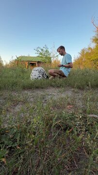 Man Training Dalmatian Dog Outdoors In Park Giving Treat