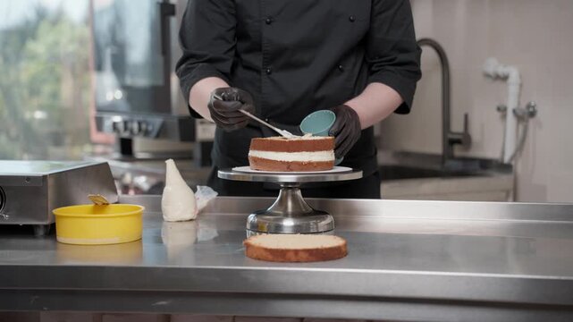 Professional pastry chef decorating layer cake with cream