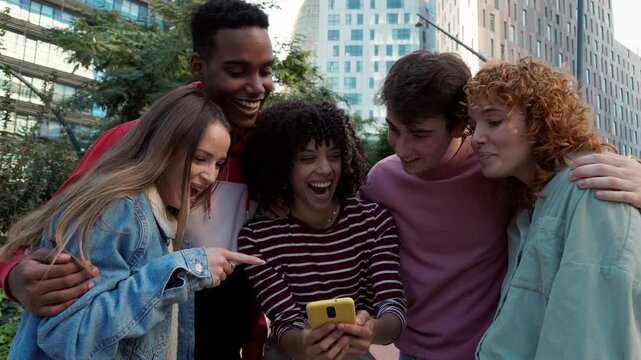 Group of diverse friends laughing together at smartphone