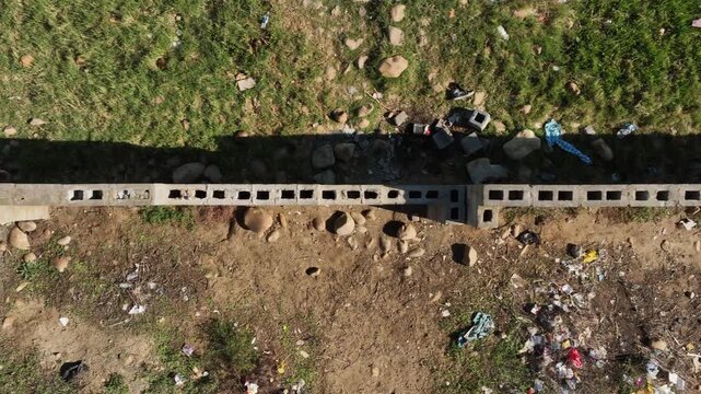 Low flyover view: Top of concrete cinder block wall being constructed