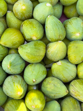 Fresh ripe green figs at local fruit market, seasonal Mediterranean produce background