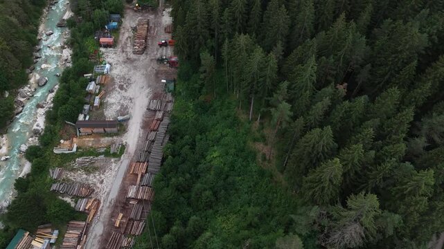 serene aerial view of forested area with river and buildings in natural setting with green and brown tones and concrete structures visible from above, capturing the tranquil beauty.
