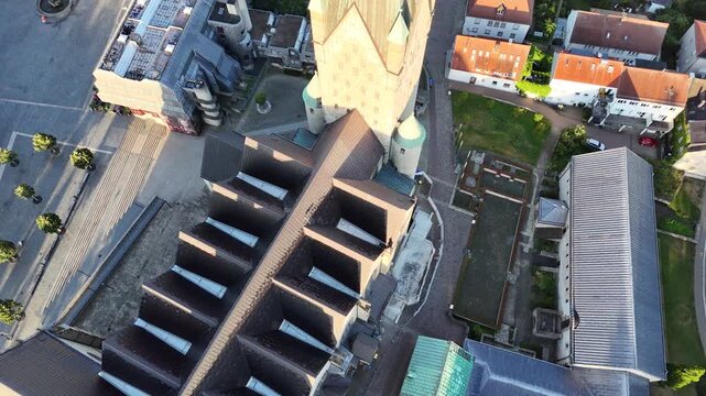 Top down drone flight tilts from the cathedral nave and tower into a sweeping orbit revealing the convent, chapel, library and skyline.