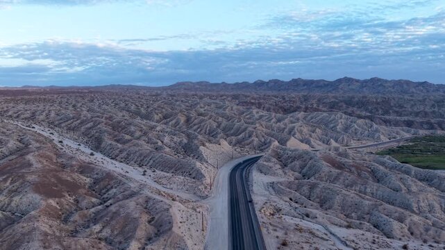 Aerial Glide above US95 follows this desert highway as it cuts through the scenic sands of the Mojave Desert at sunrise. A long lonely hwy through the hot Nevada desert along side the Colorado River.