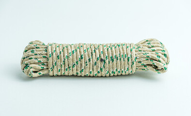 Rolled bundle of green and white twisted string rope isolated on white background © Meilan Photography
