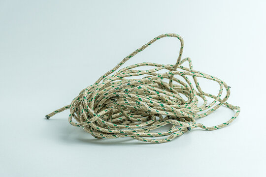 Messy tangled pile of green and white twisted string isolated on white background