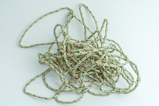 Messy tangled pile of green and white twisted string isolated on white background