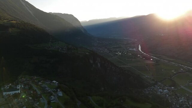 serene mountain landscape at sunset with roads cutting through the valley, aerial perspective showing natural beauty and peacefulness , Ergisch