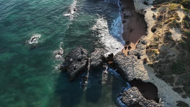 serene rocky coastline aerial view with ocean waves and natural scenery in blue and green tones, a peaceful coastal landscape with rocks and water, a tranquil scene of nature's beauty frome.