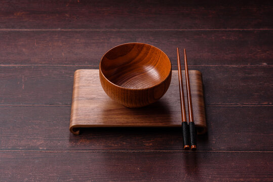 An empty round wooden plate on a textured background. An empty round plate