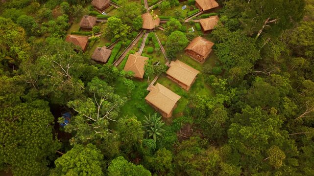 Drone ascending over an indigenous community in the lush ecuadorian amazon rainforest near a river