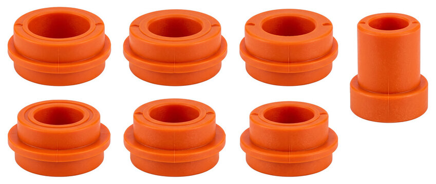 Orange polyurethane bushings spare parts isolated on black background for skateboard truck suspension maintenance industrial hardware component set durable elastomer ring spacers replacement.
