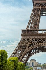 looking down the champ de mars to the Eiffel Tower standing tall with grass and gardens below and clear blue summer skies overhead on sunny day © STJMEDIA